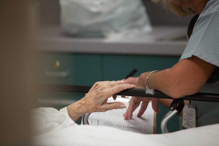 Older adult and family caregiver reviewing home care and assisted living costs at a kitchen table.